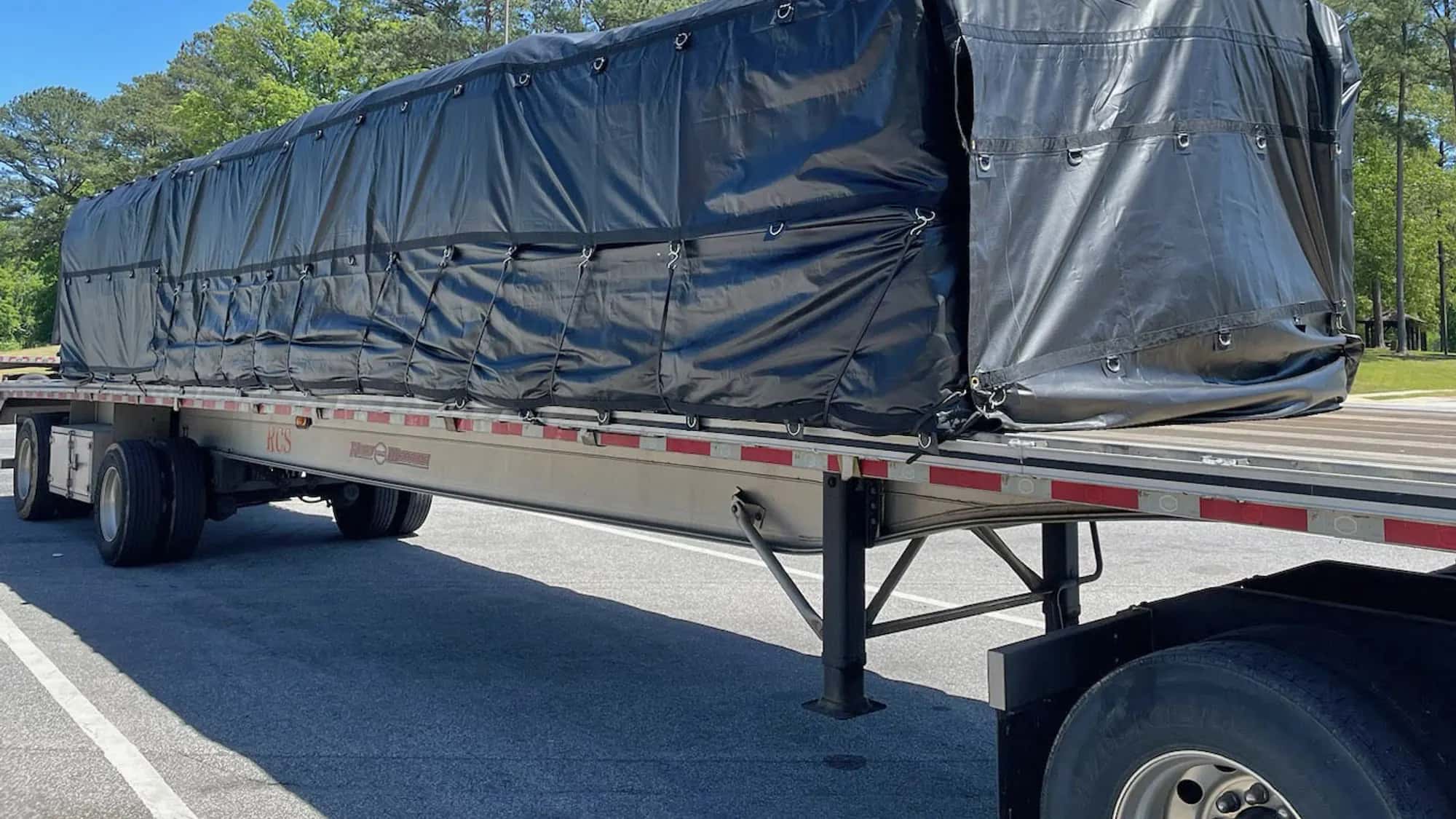 Tarped and strapped load riding a 53-foot flatbed trailer