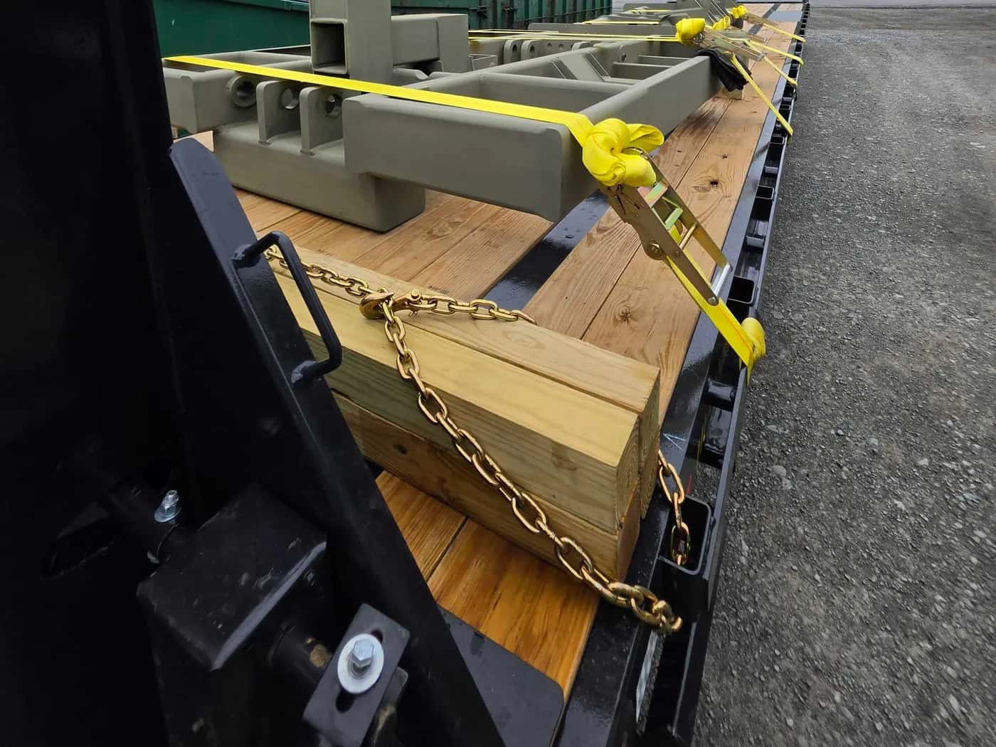 Ratchet straps and transport chains securing machinery to a trailer deck